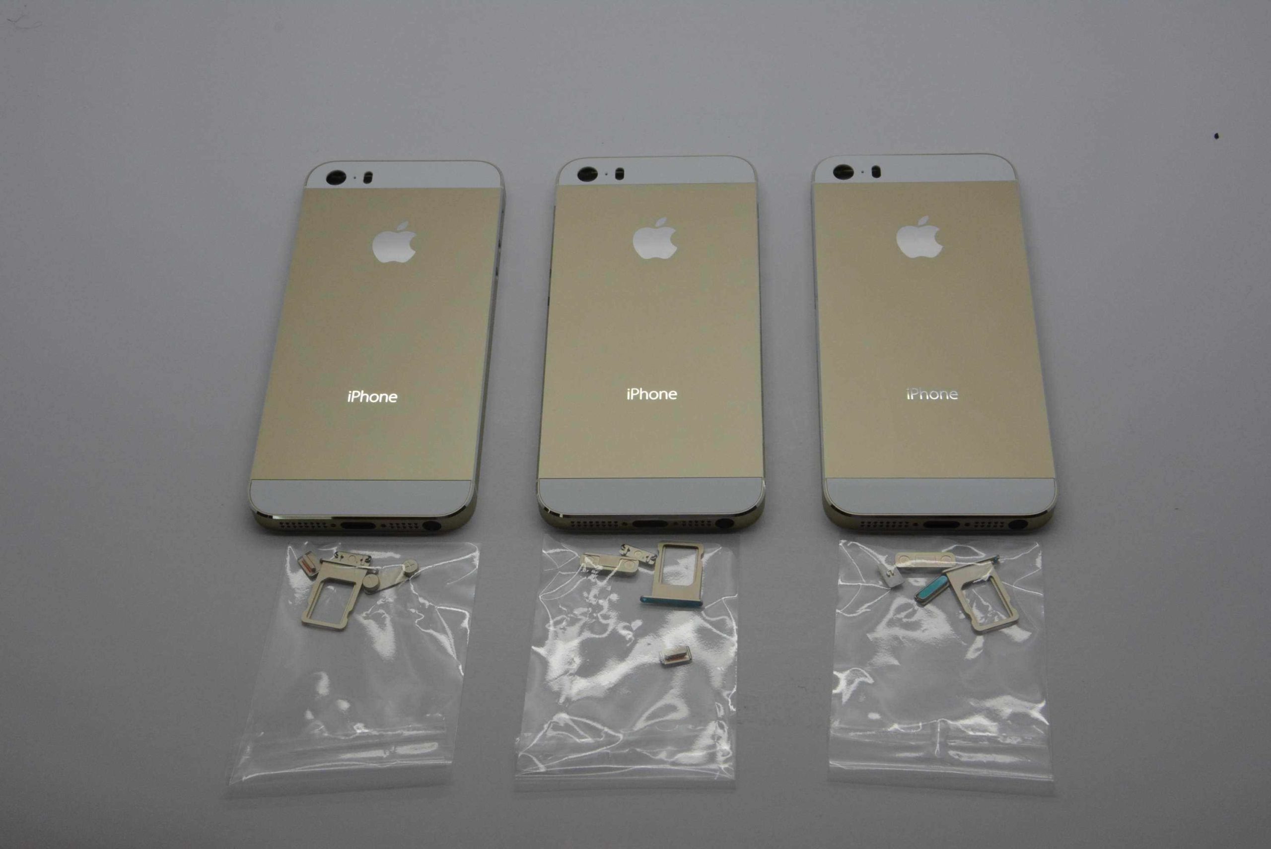 three gold smartphones with accessories