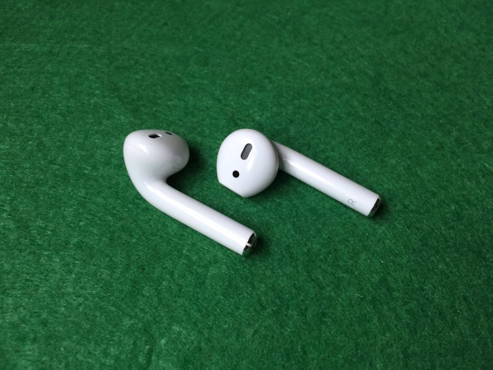 wireless earbuds on green