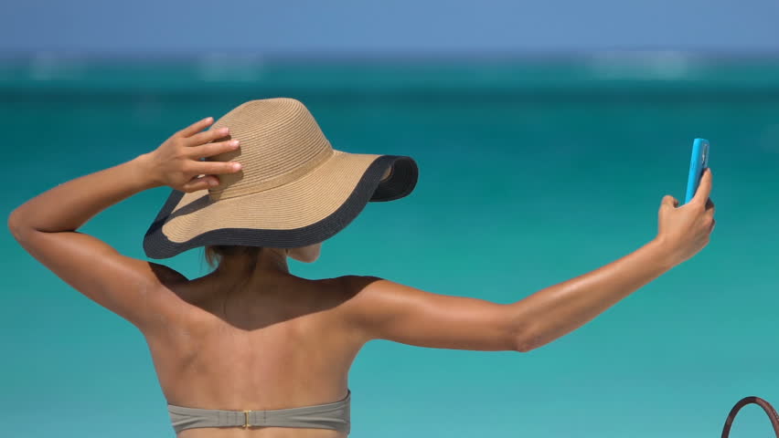 woman taking selfie on beach
