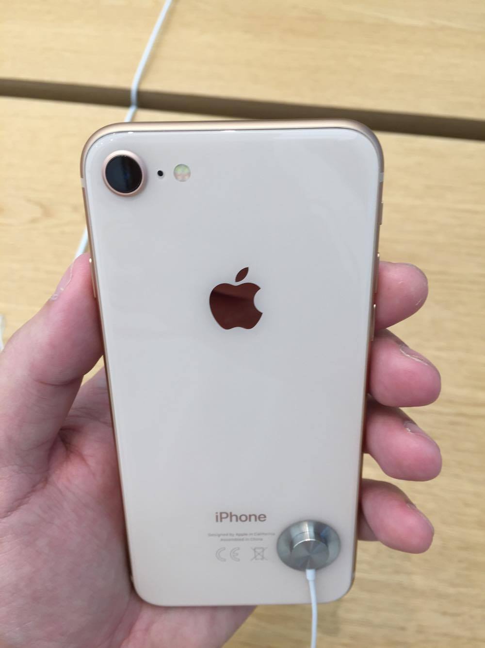 hand holding gold iphone back single camera