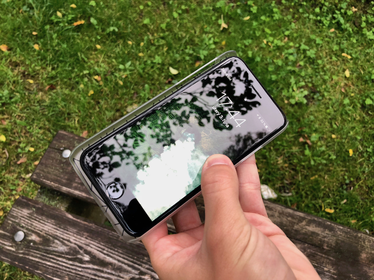 hand holding smartphone on bench