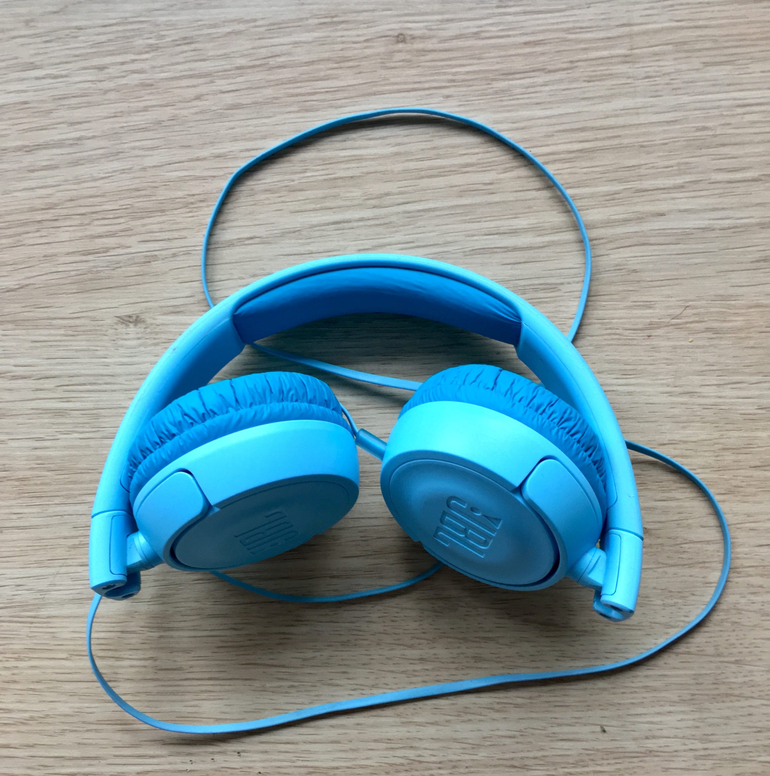 blue headphones on wooden surface