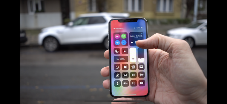 hand holding phone with cars