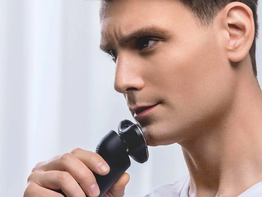 man using electric shaver