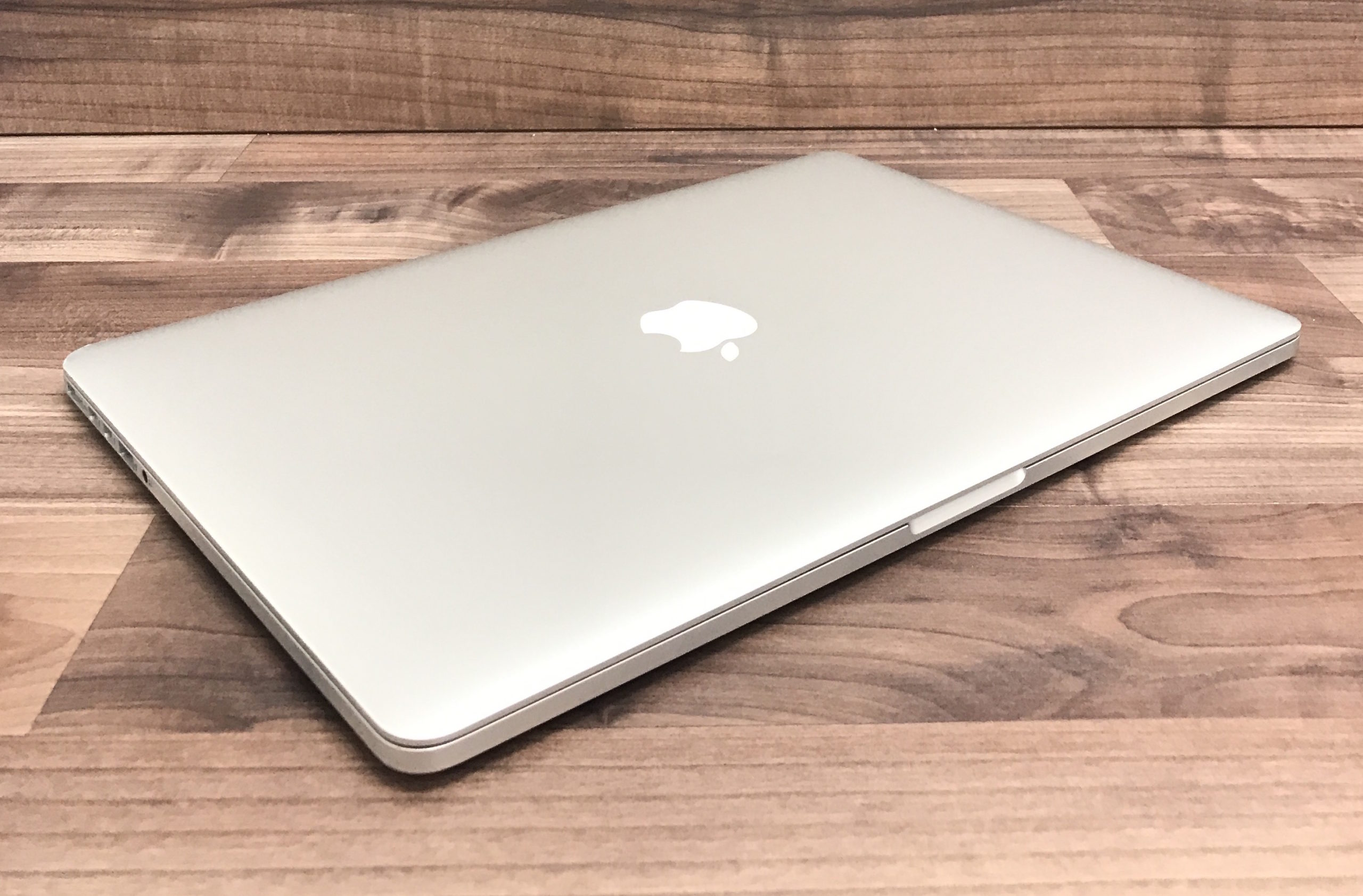 angled view silver laptop wooden surface