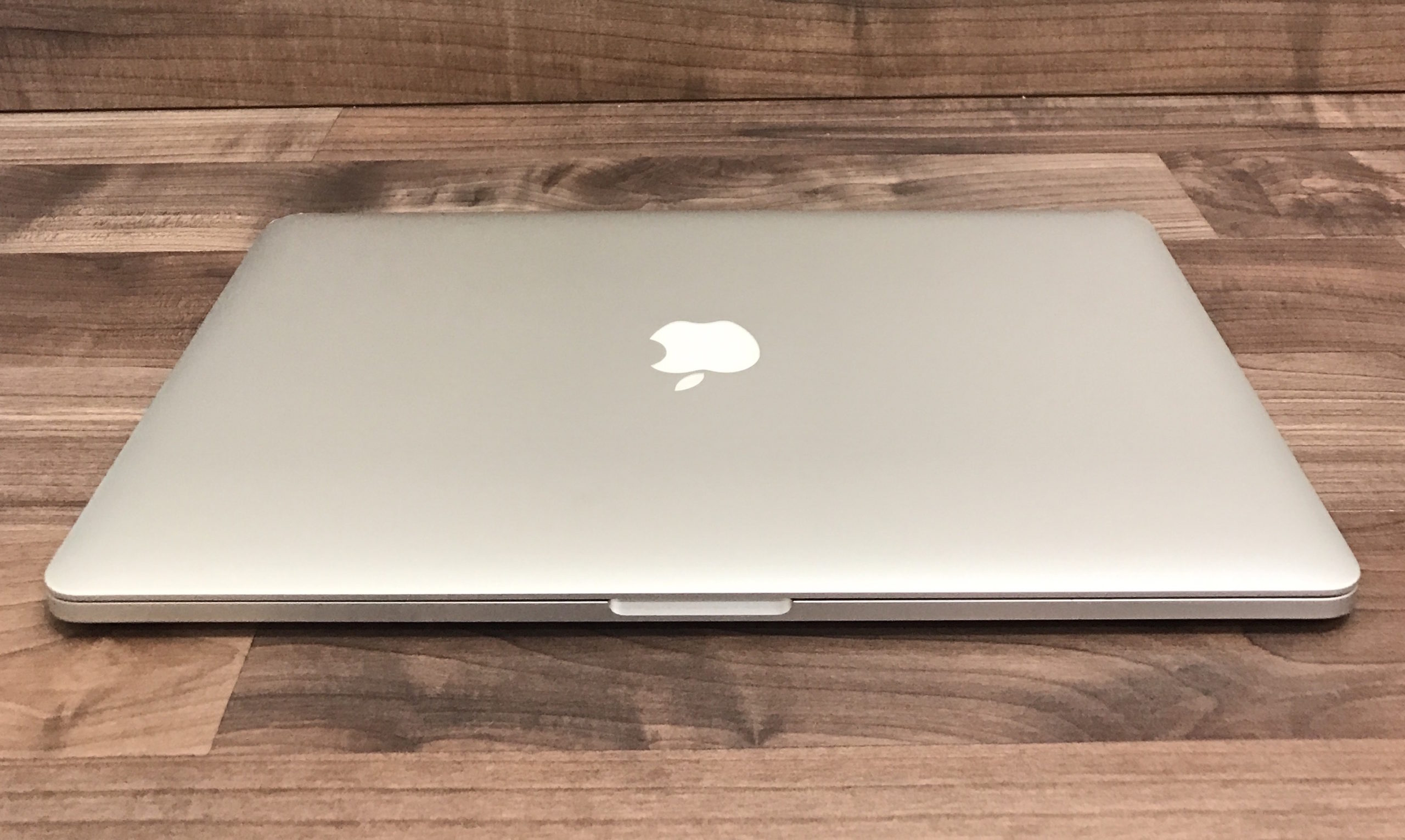 closed silver laptop on wooden table