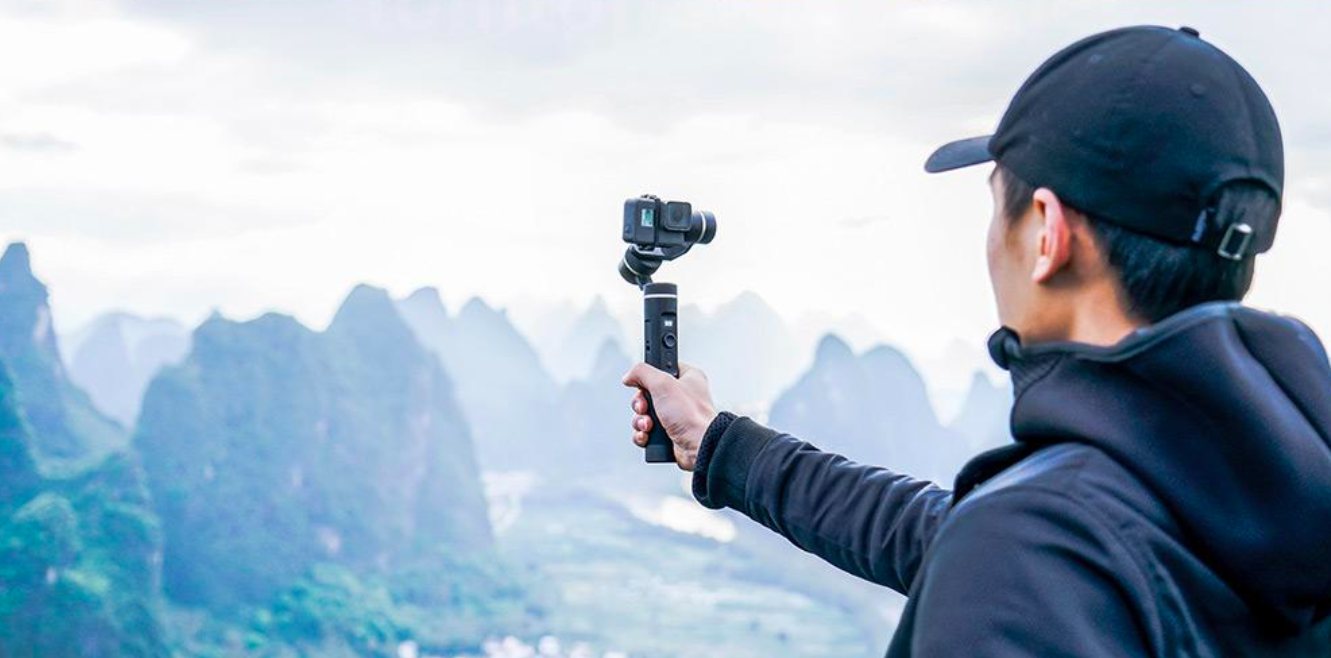person holding gimbal mountain view