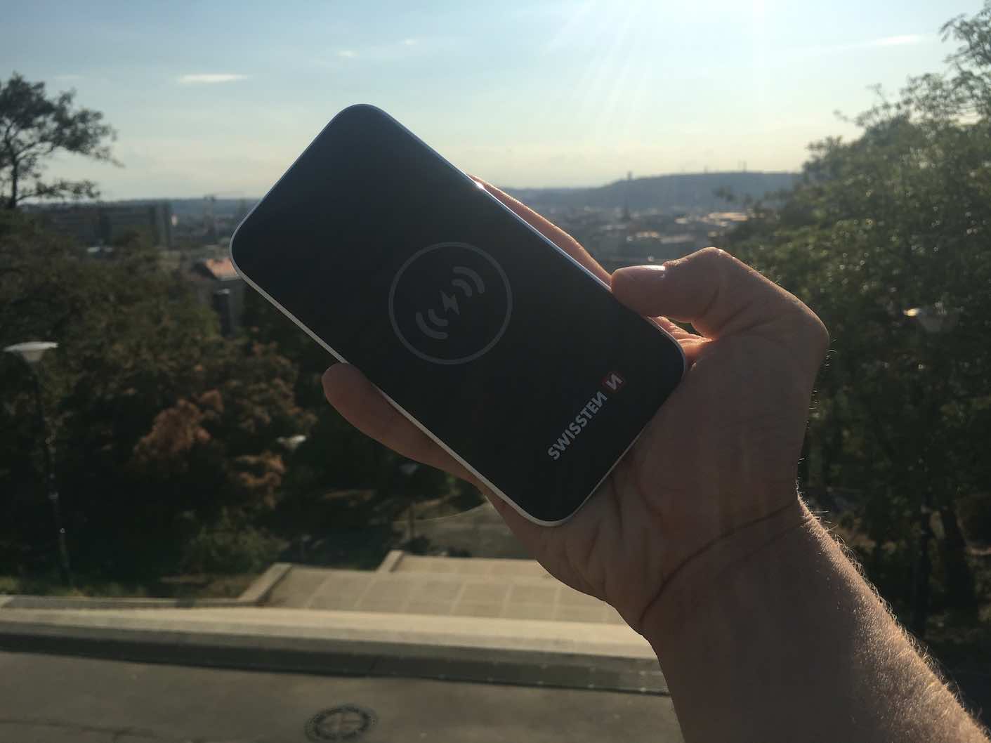 hand holding wireless power bank outdoors