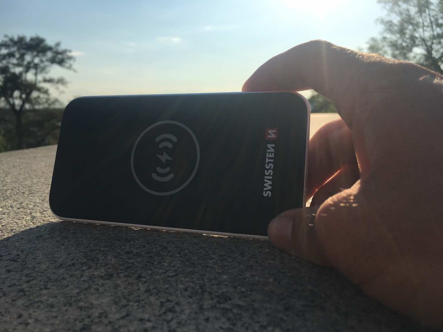 hand placing wireless power bank on surface