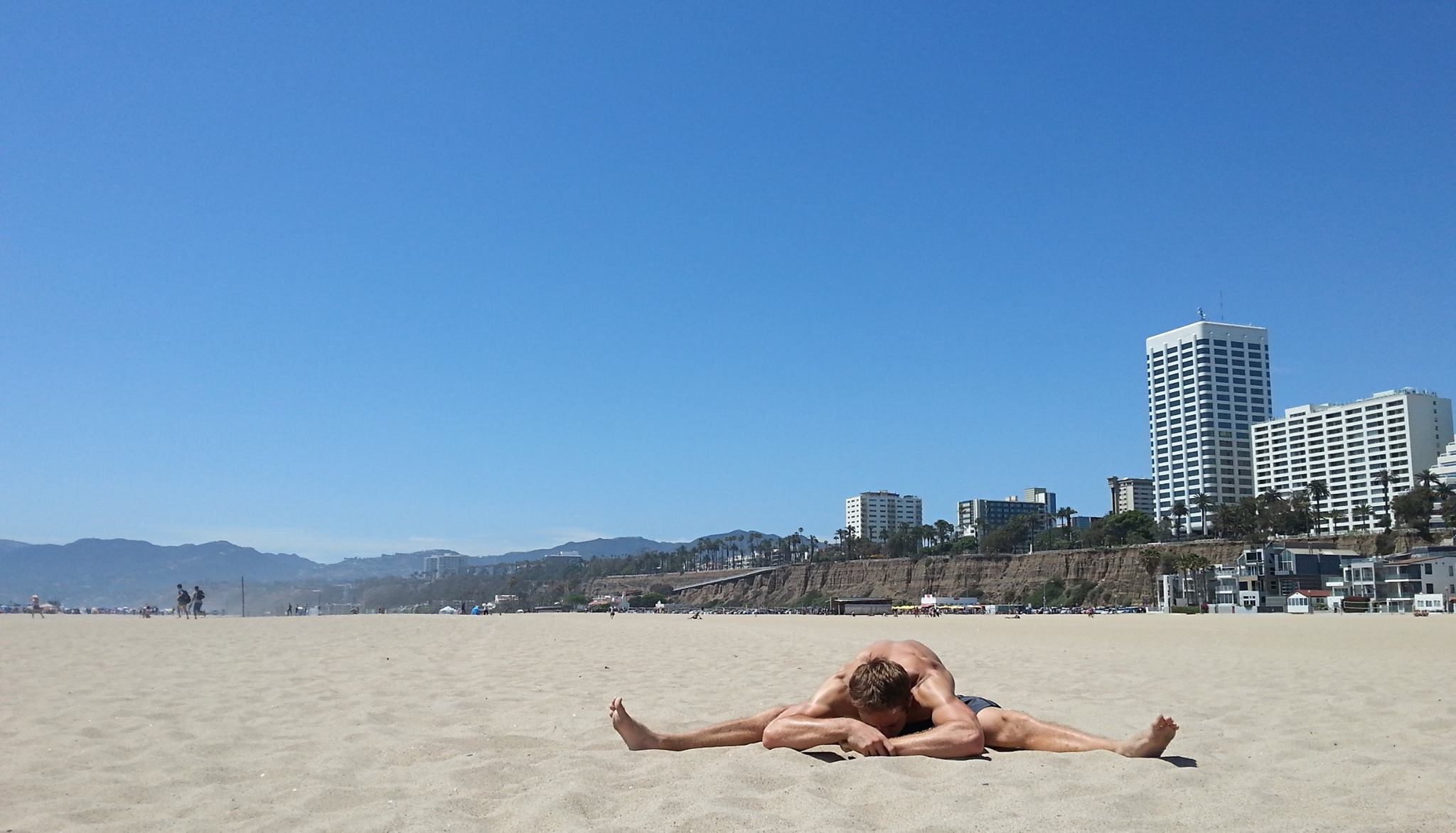 man stretching beach