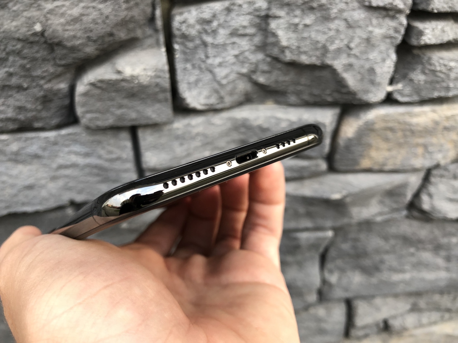 holding iphone bottom view stone wall holding iphone bottom view stone wall