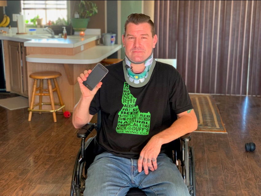 man in wheelchair holding phone