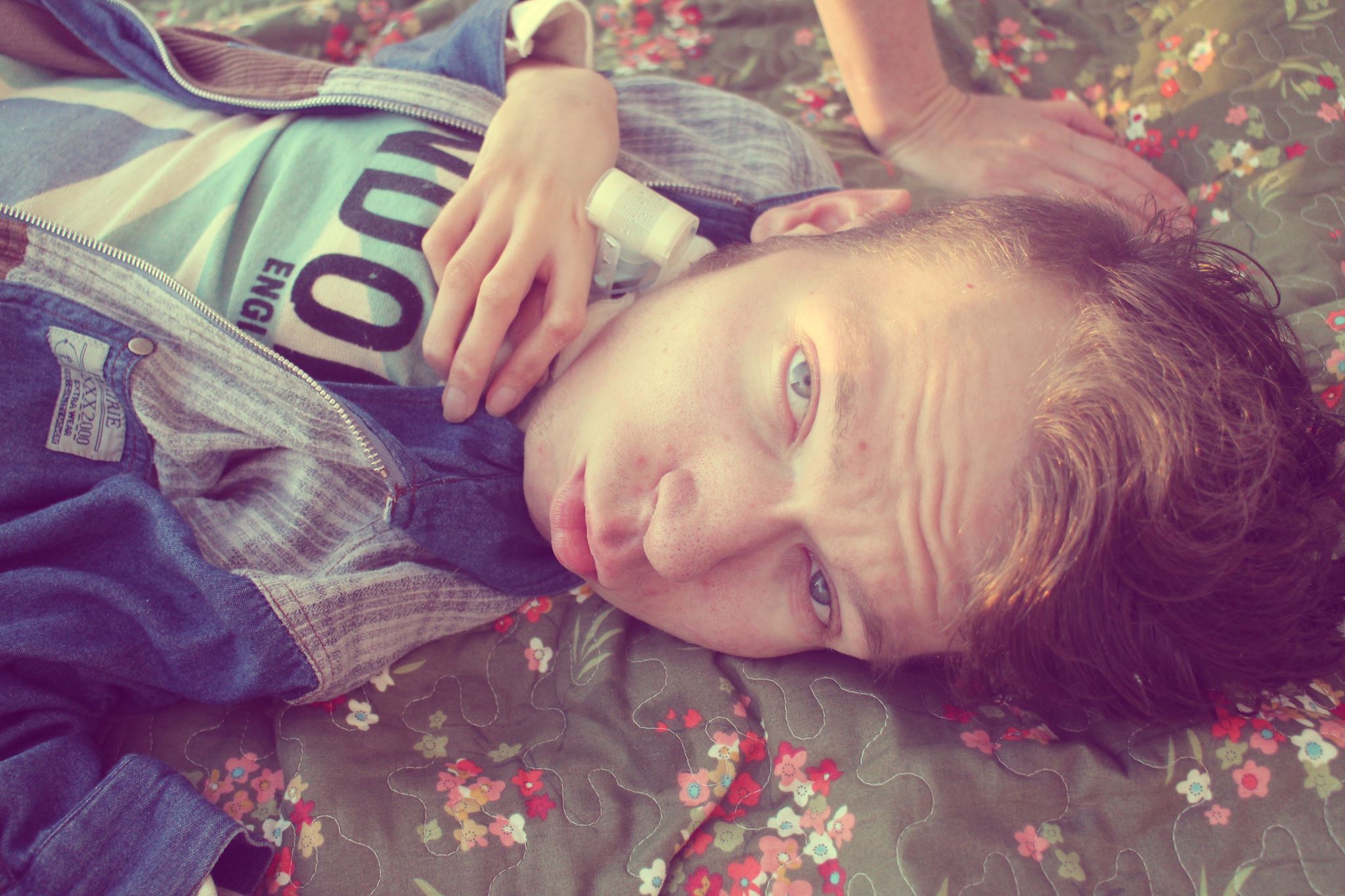 person lying on floral blanket