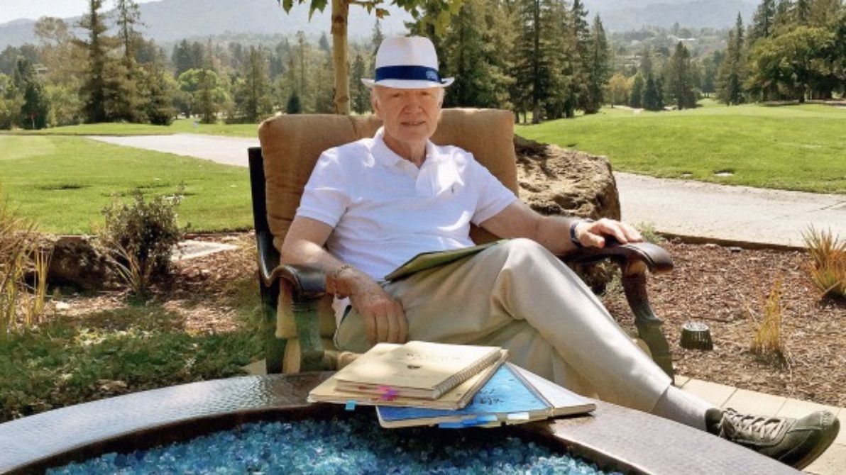 man sitting outdoors with books