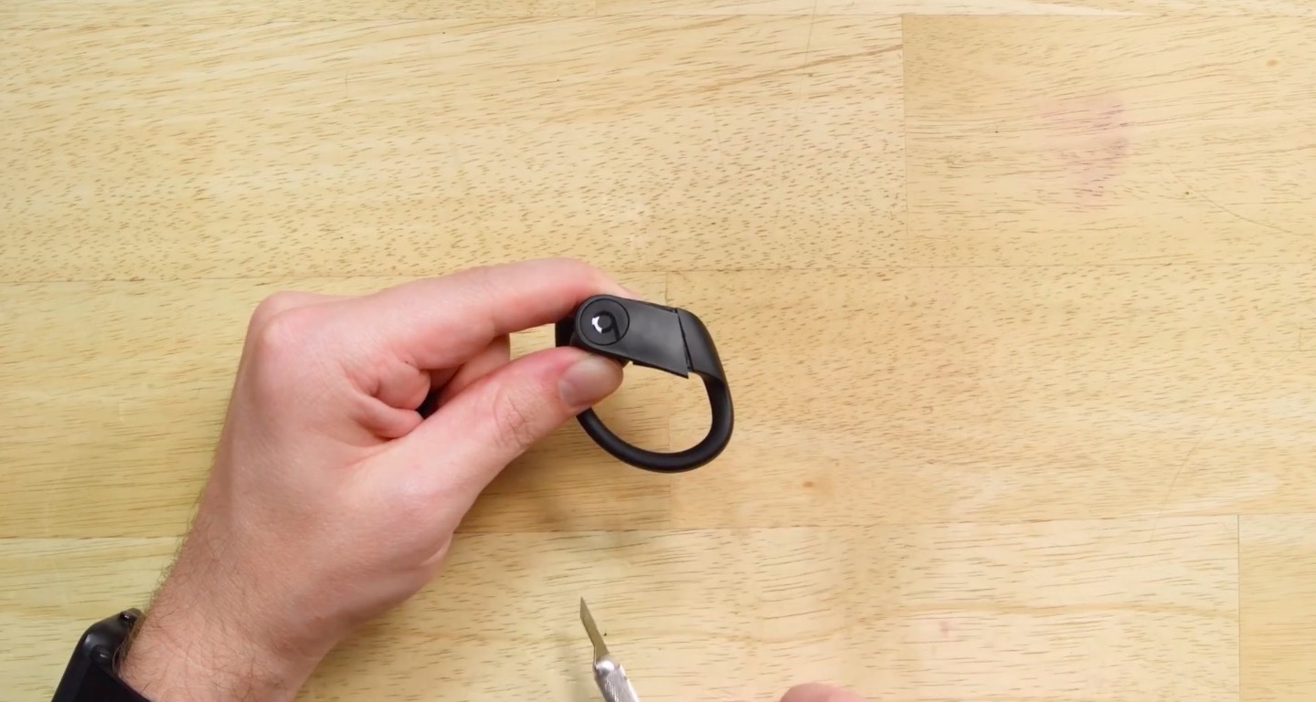 holding earbud on table