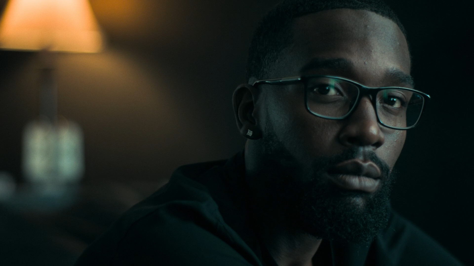 man with glasses in dark room
