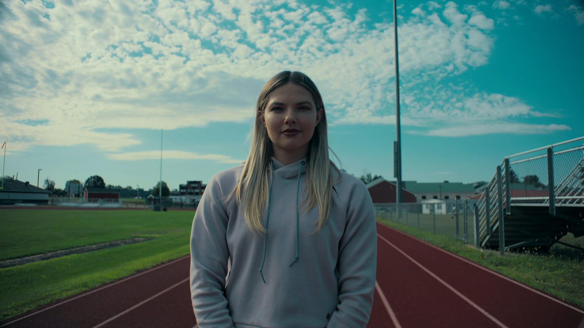 woman on track with cloudy sky