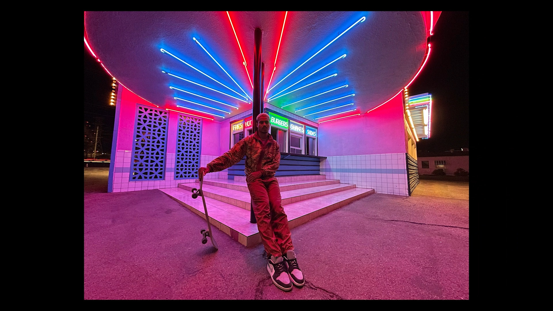 skateboarder under neon lights