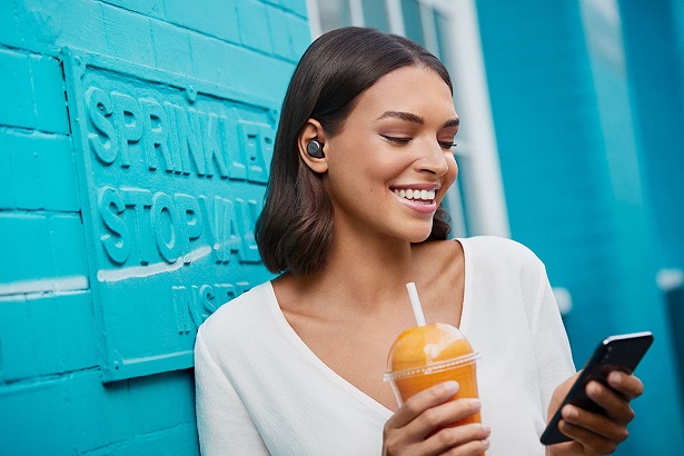 smiling woman with smoothie and phone