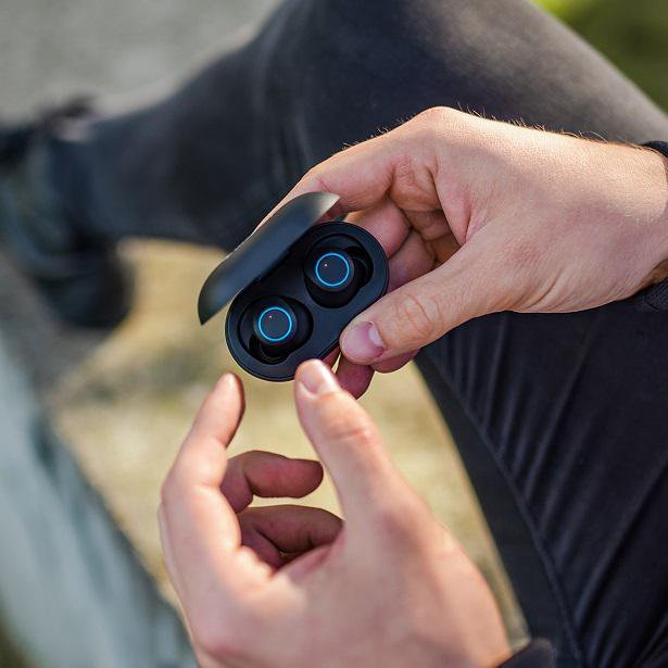 close up of wireless earbuds in hand
