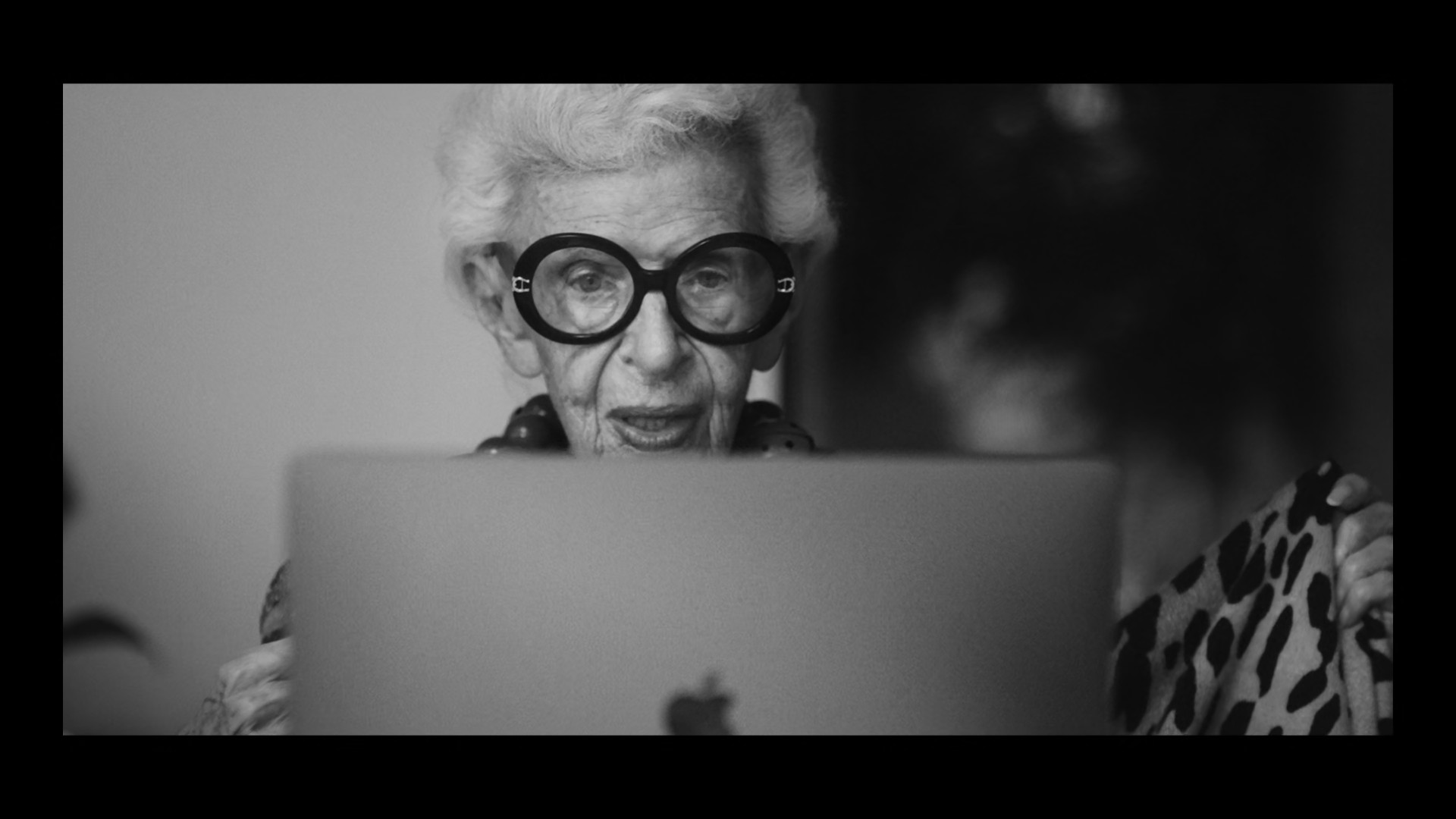 elderly person with glasses and laptop