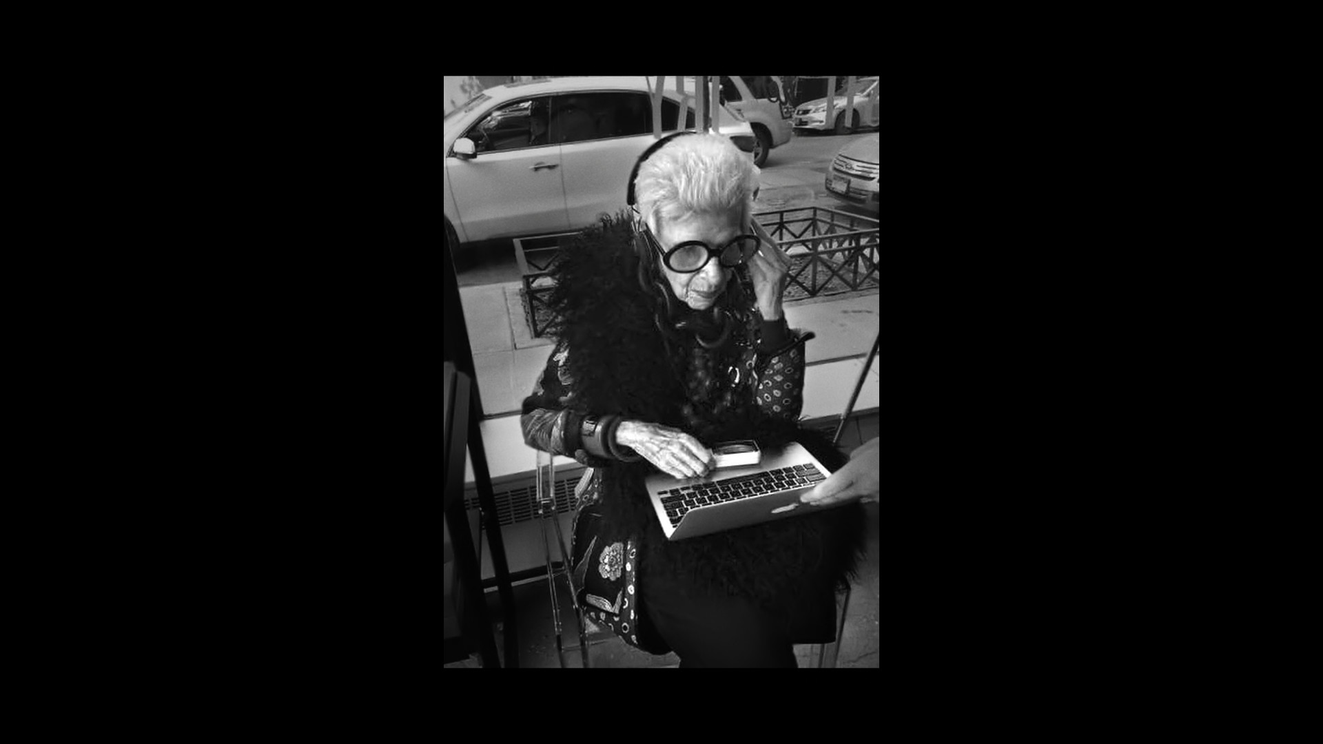 elderly person with headphones and laptop