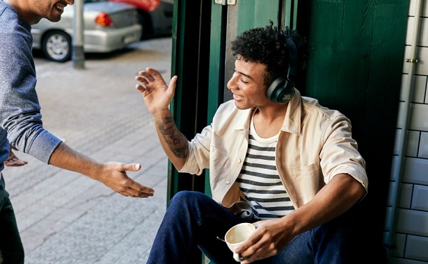 man greeting friend with headphones
