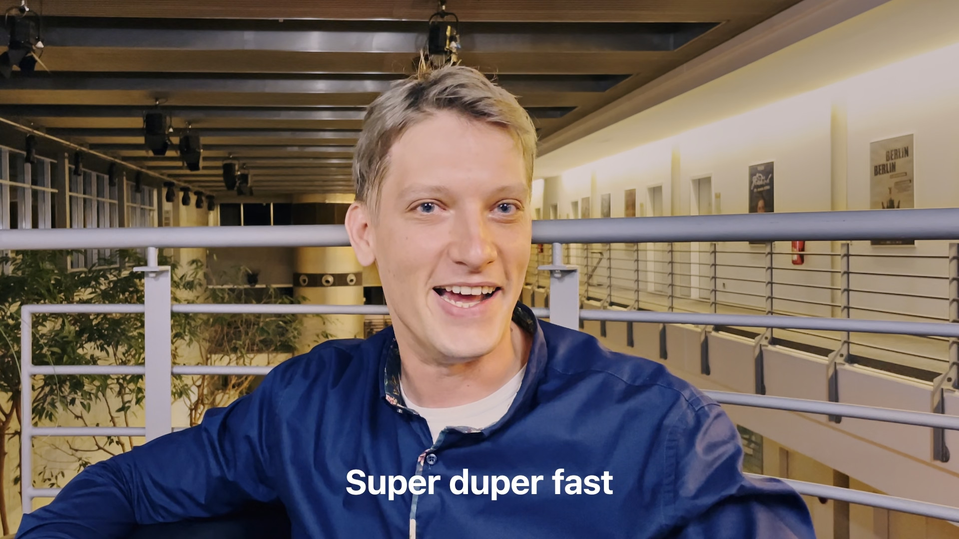 man in blue jacket with text