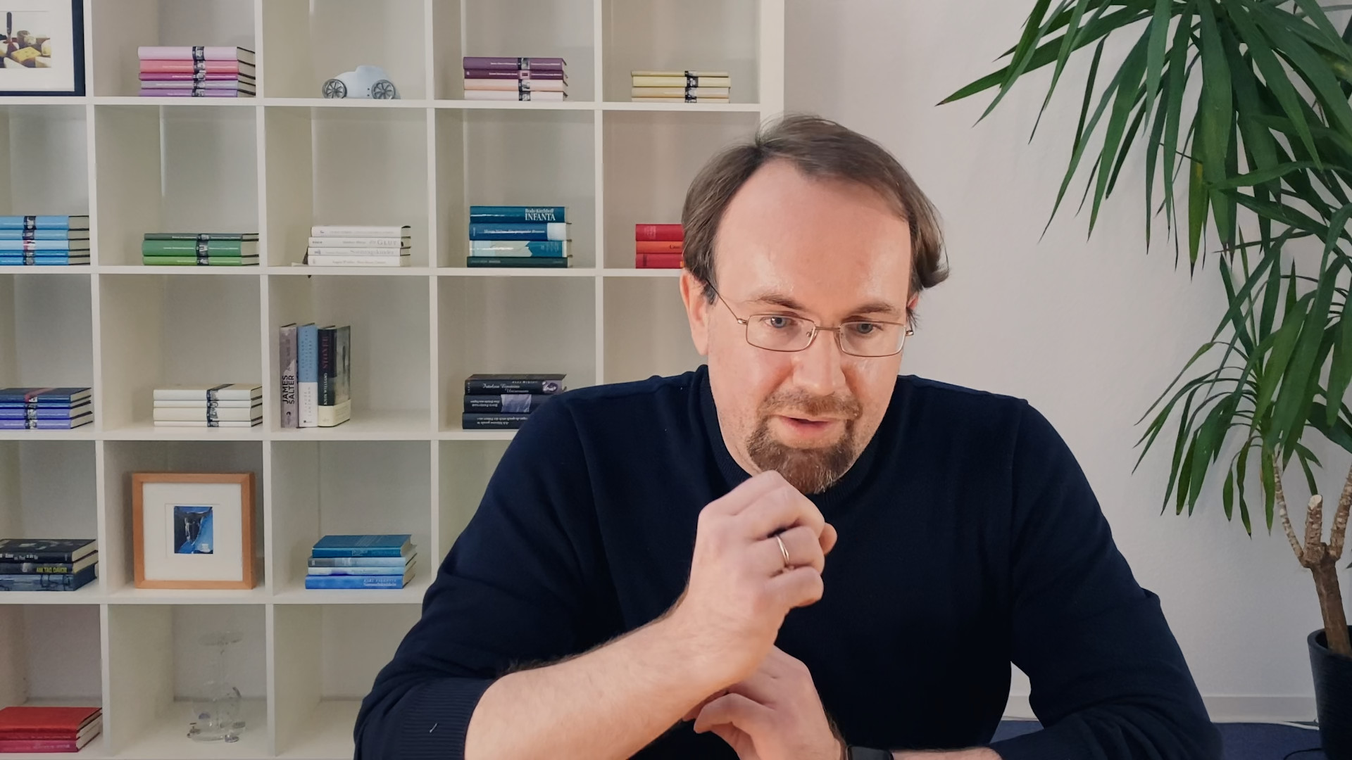 man in front of bookshelf