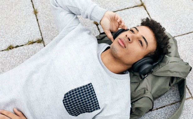man lying on ground with headphones