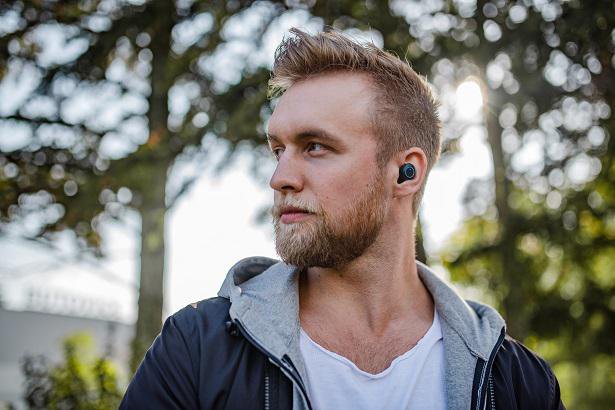 man with earbuds in park