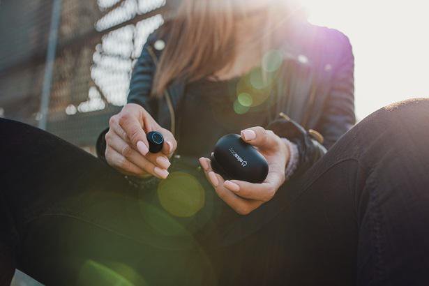 person holding wireless earbuds case