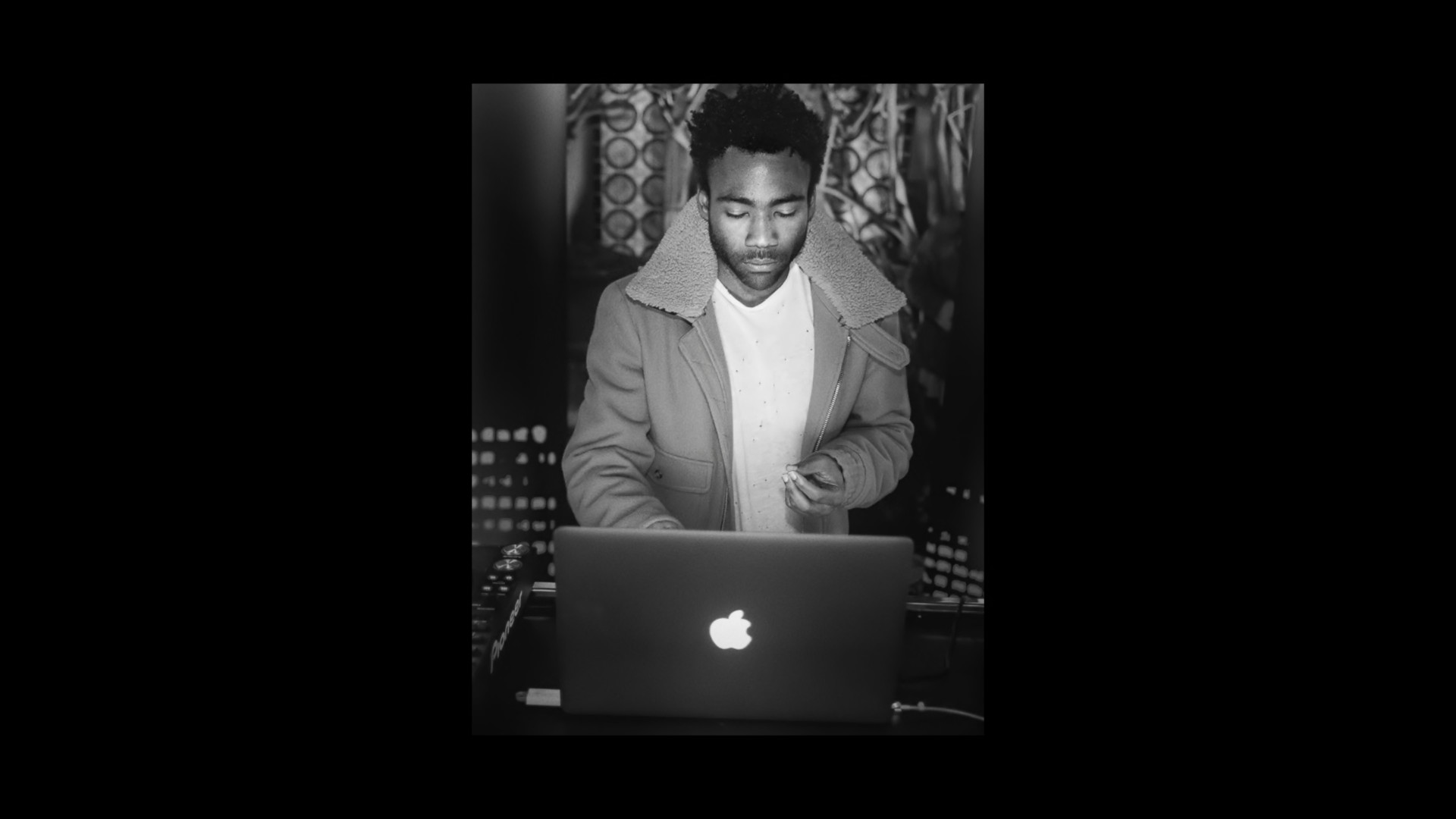 person in coat using laptop