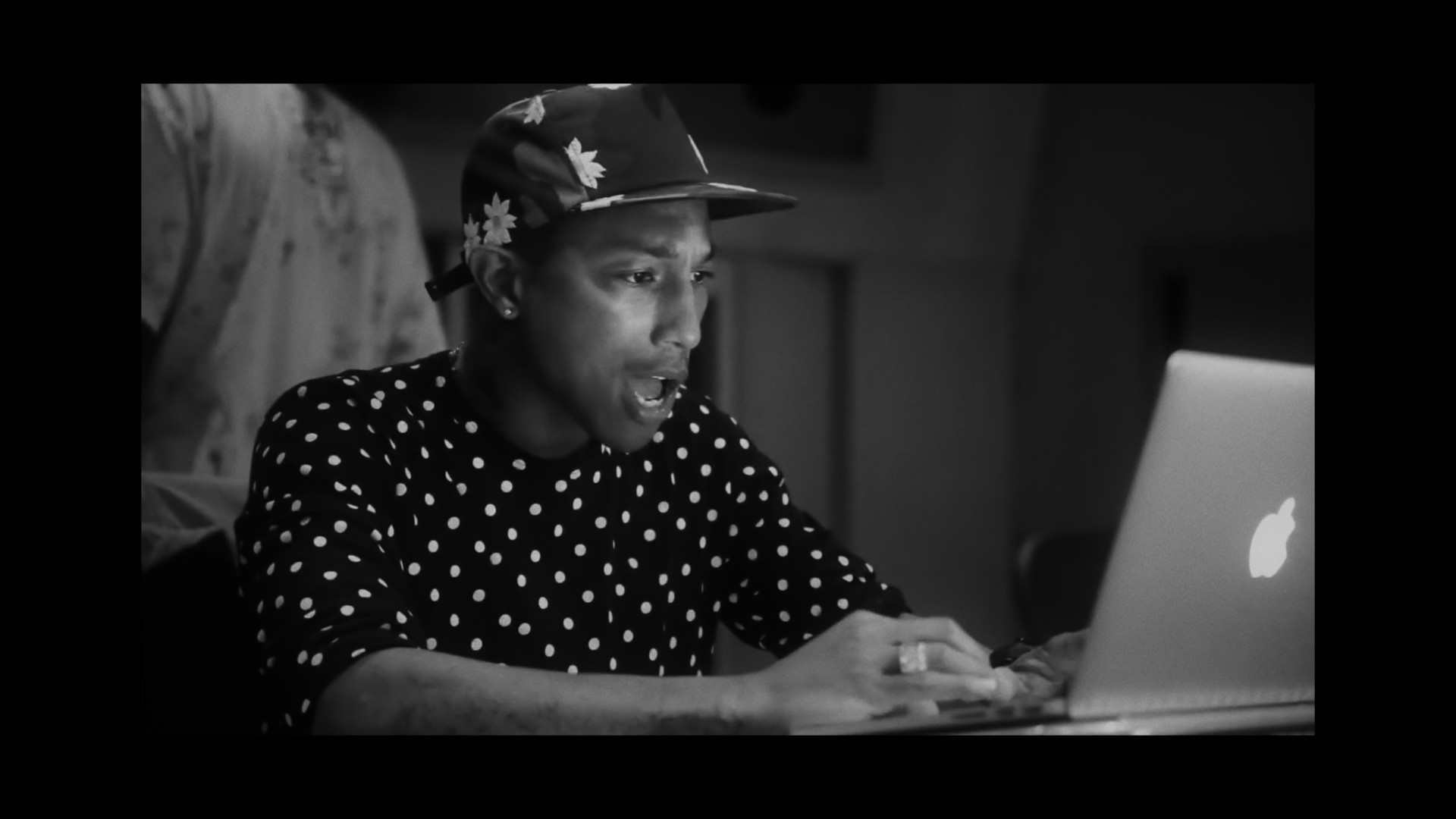 person in polka dot shirt with laptop