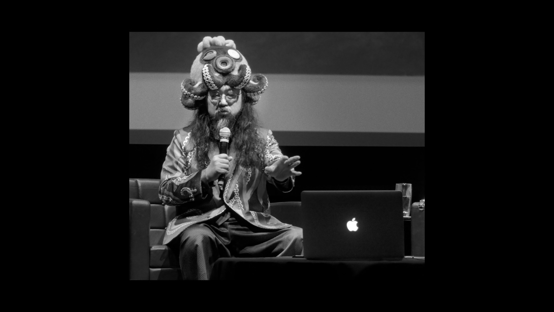 person with ornate headgear and laptop