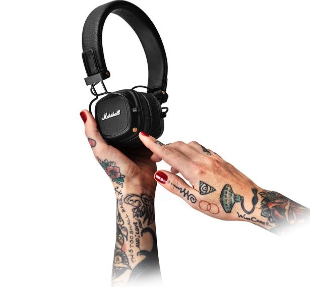 tattooed hands holding headphones