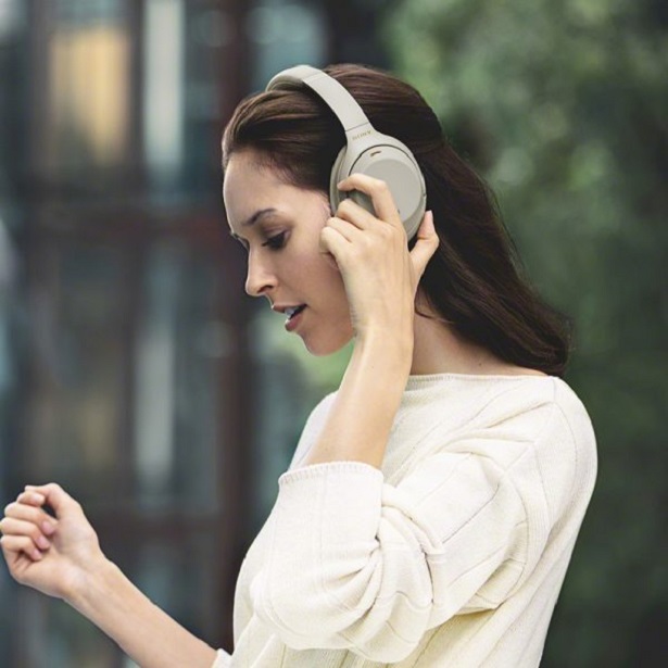 woman adjusting headphones outdoors