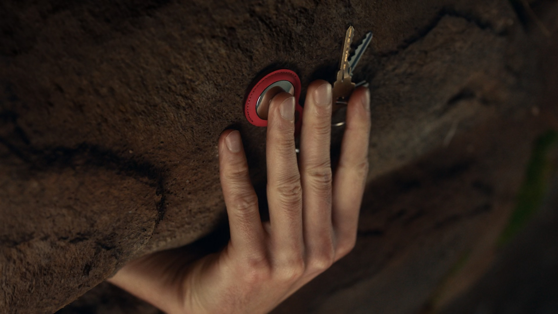 hand holding key and tracker