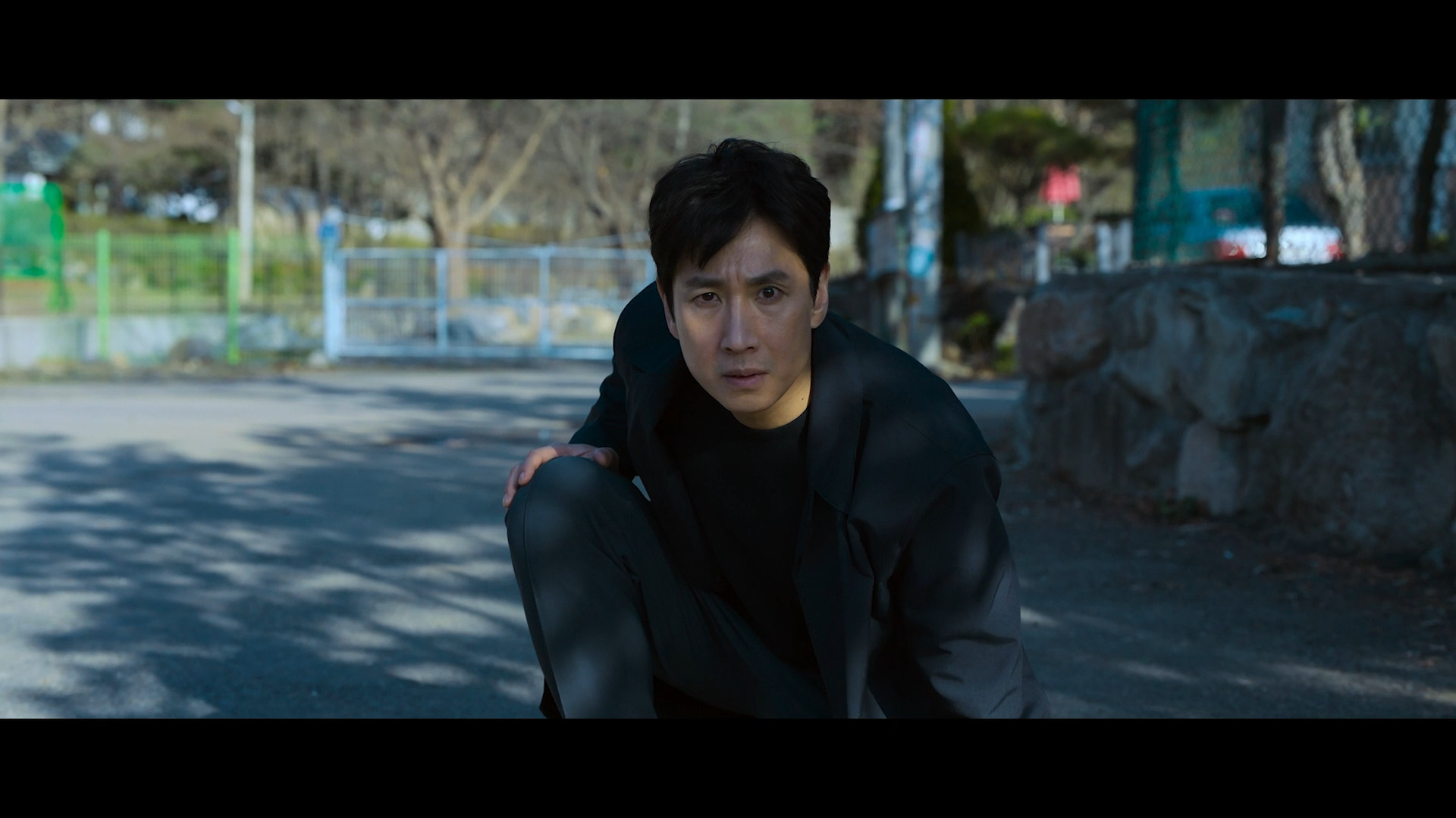 man crouching outdoors