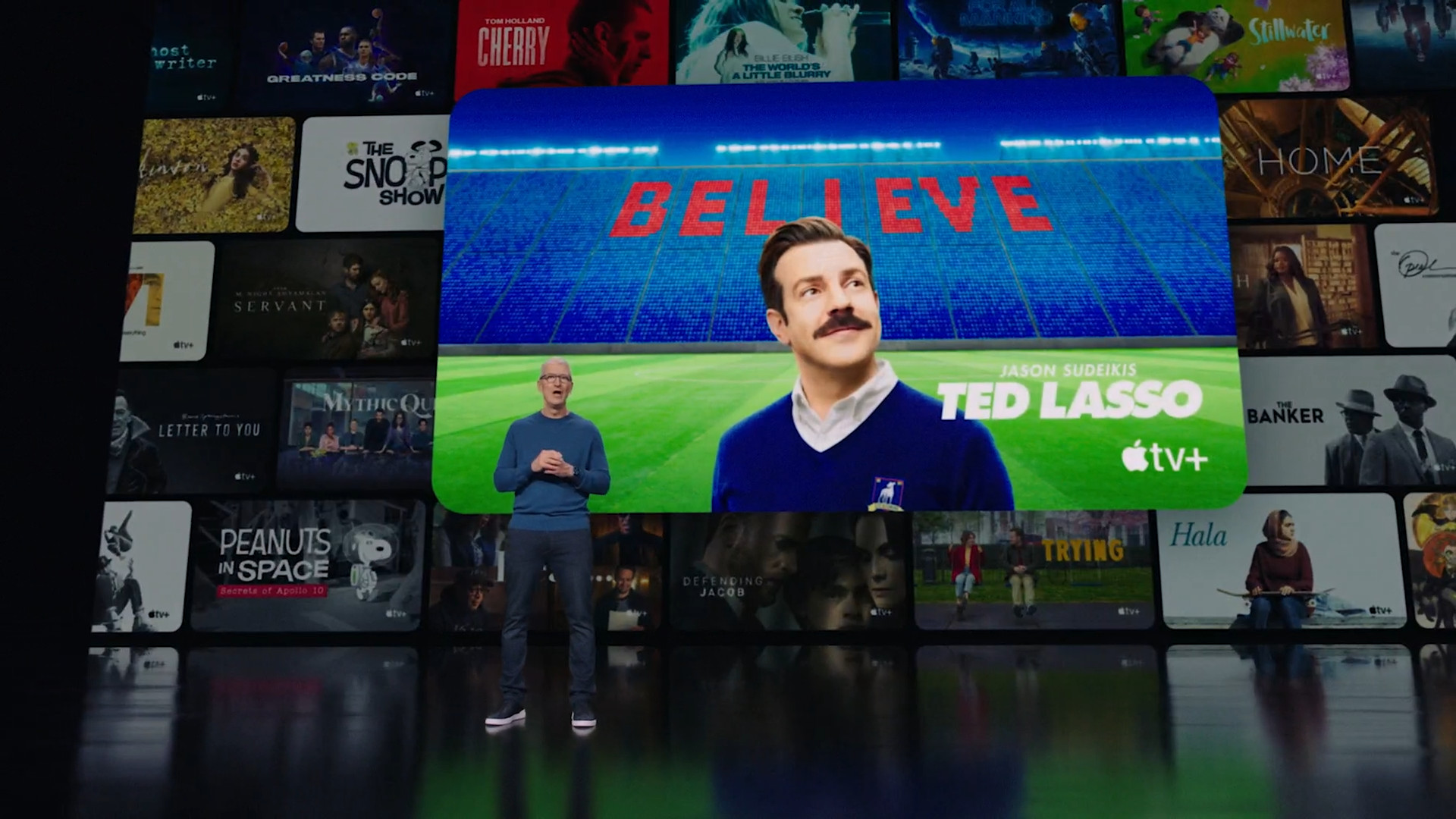 person in front of ted lasso poster