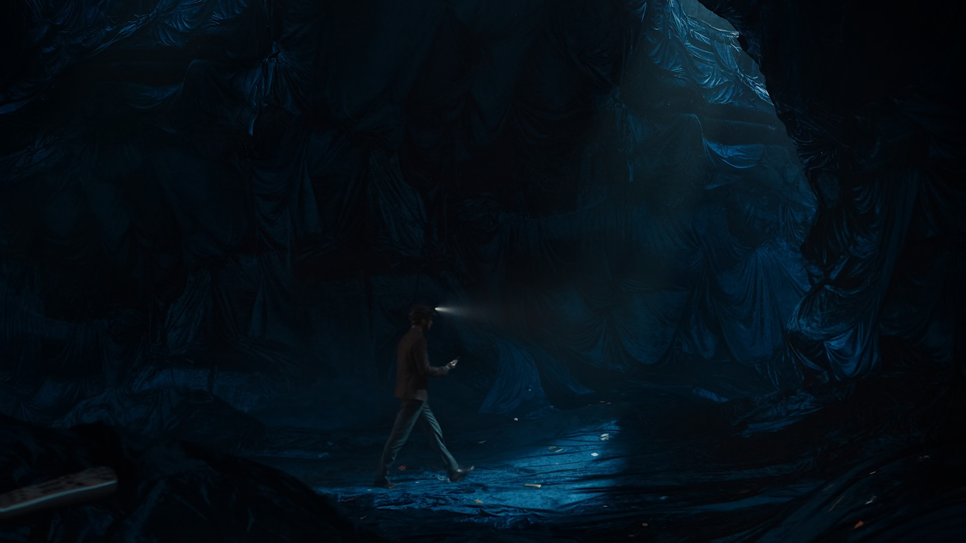 person walking in dark cave