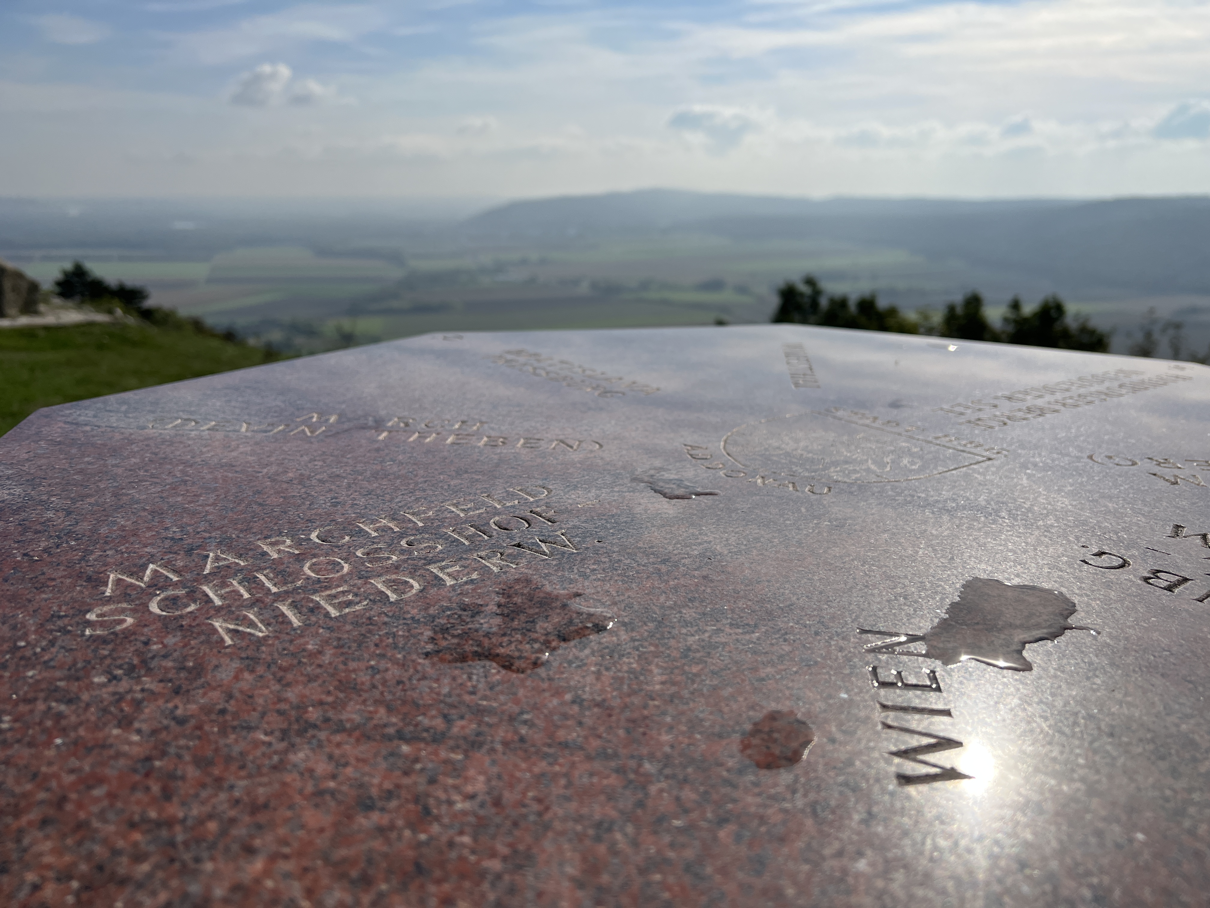 stone table with engraved text overlooking landscape