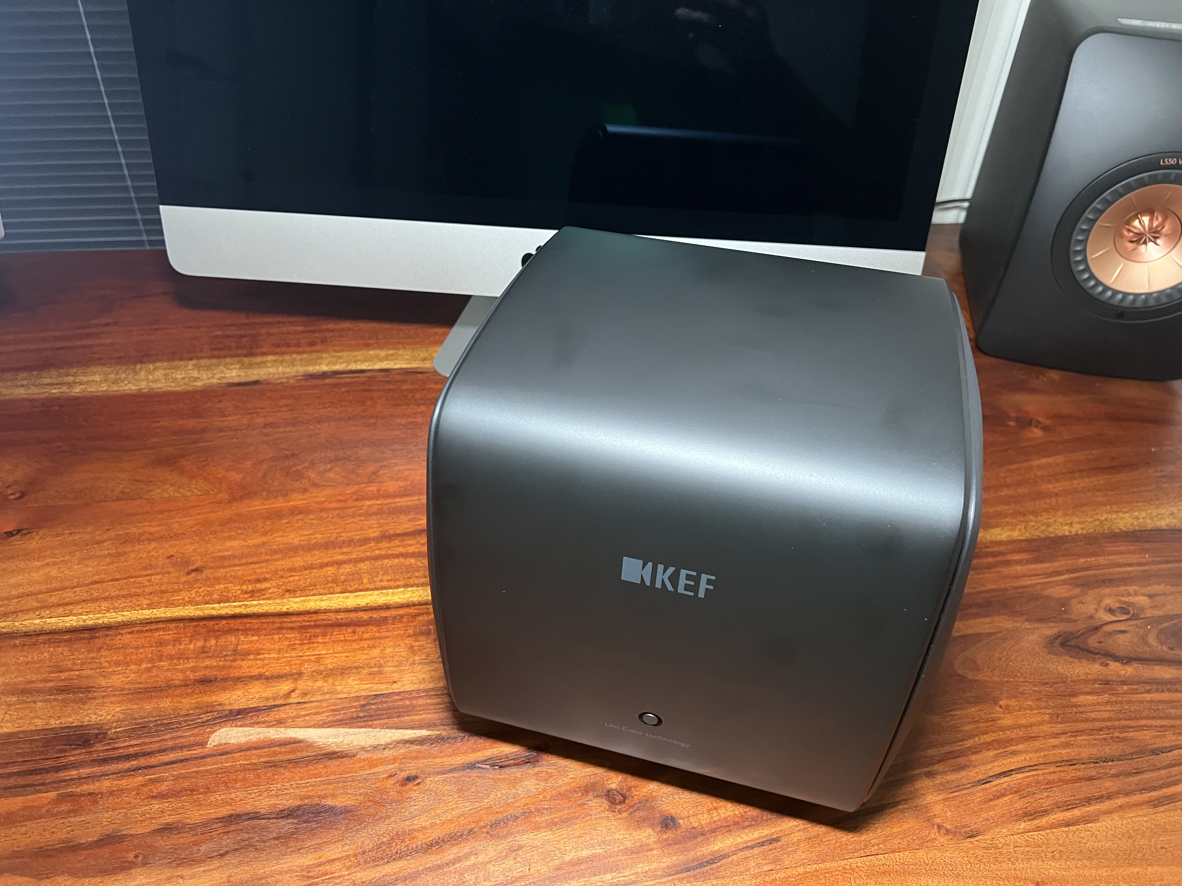 black kef subwoofer on desk