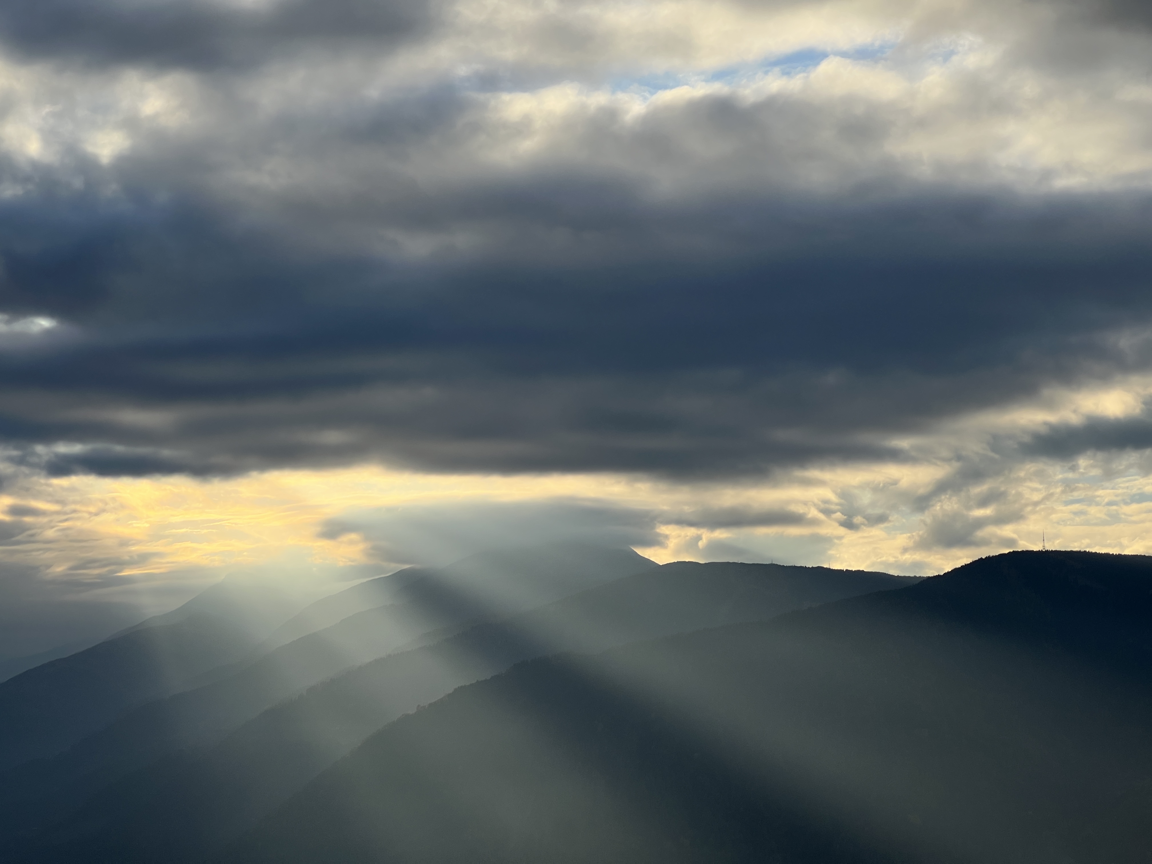 sun rays through clouds over mountains