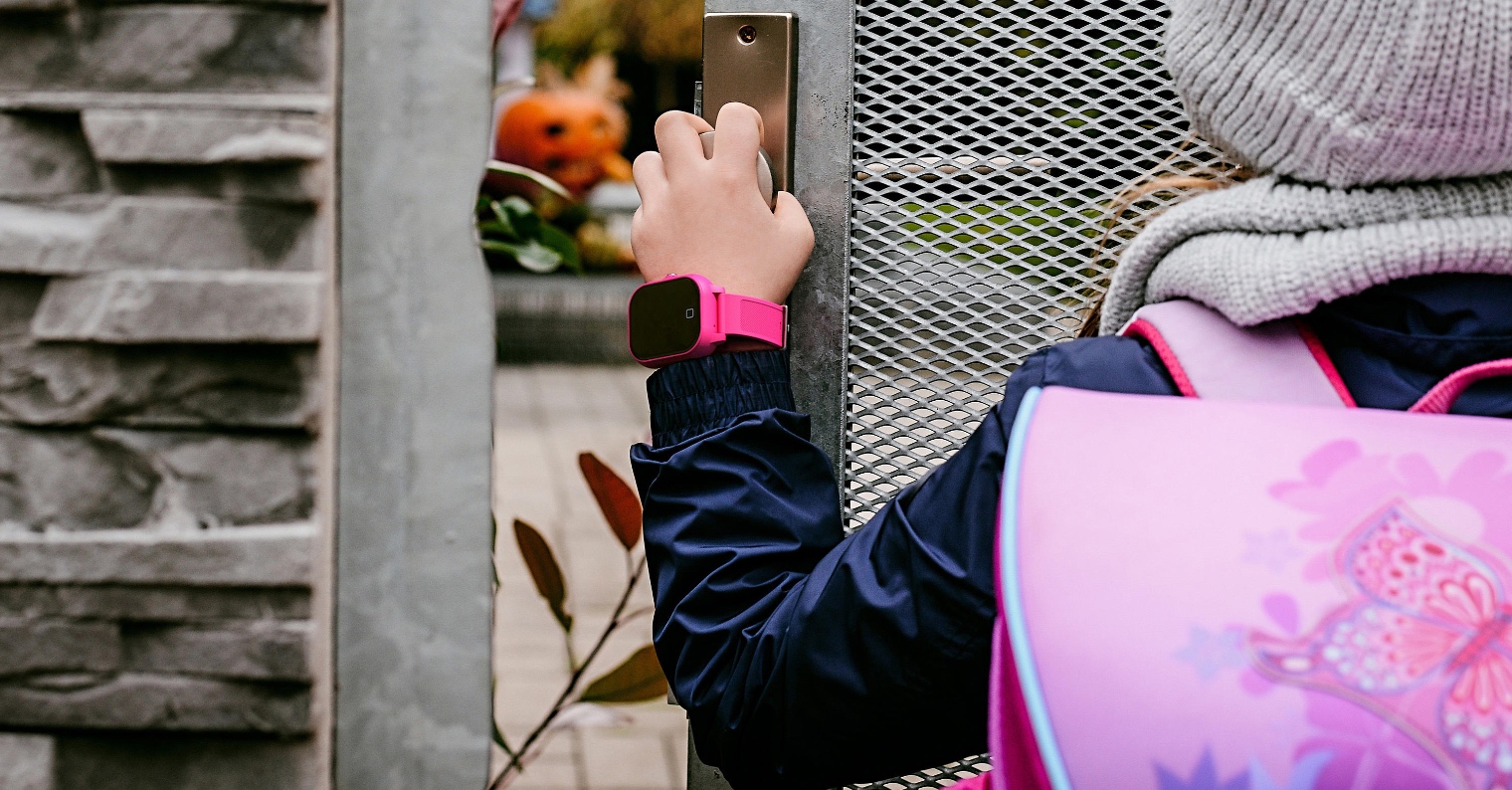 child with smartwatch at gate