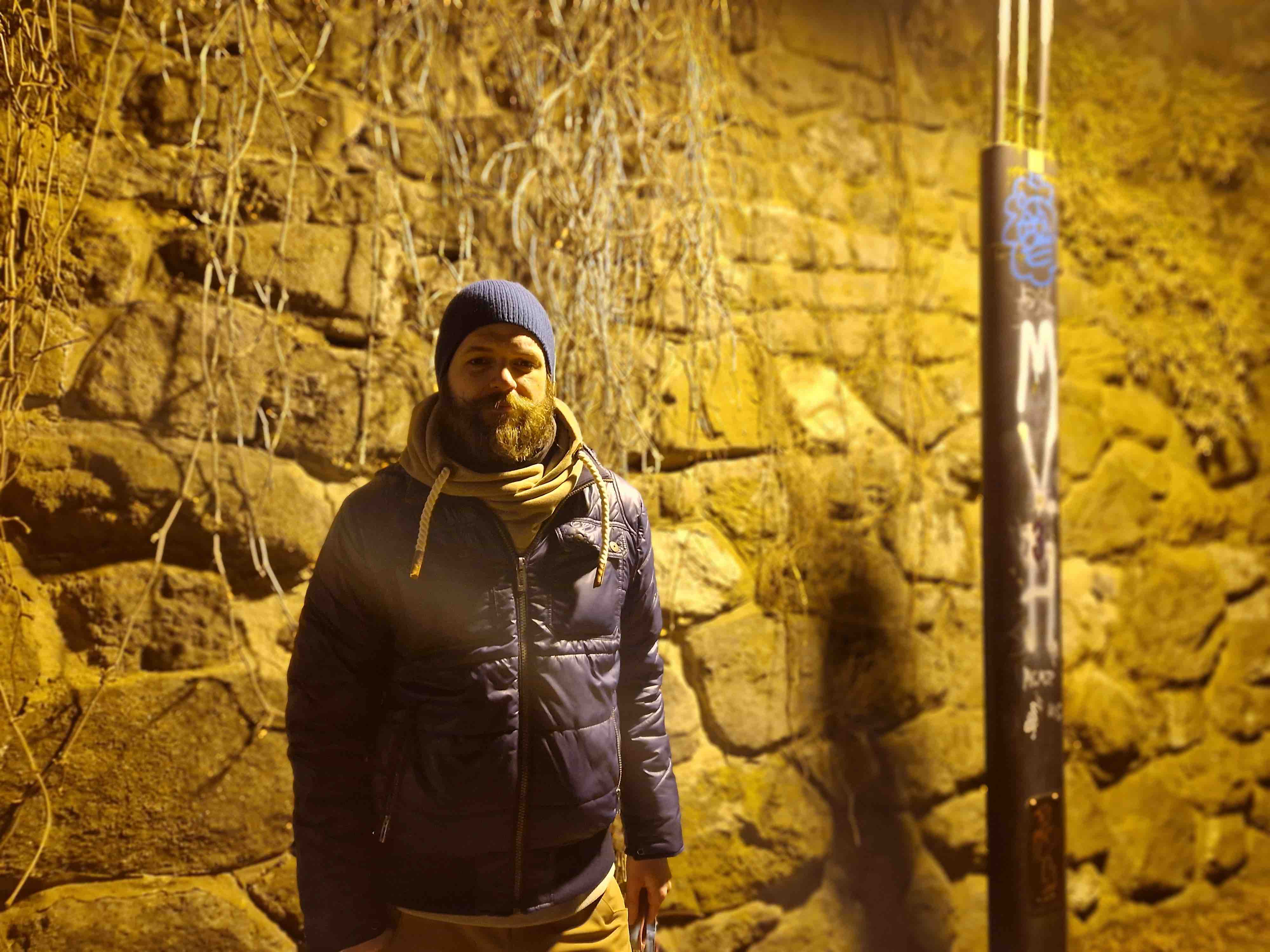 man standing by stone wall