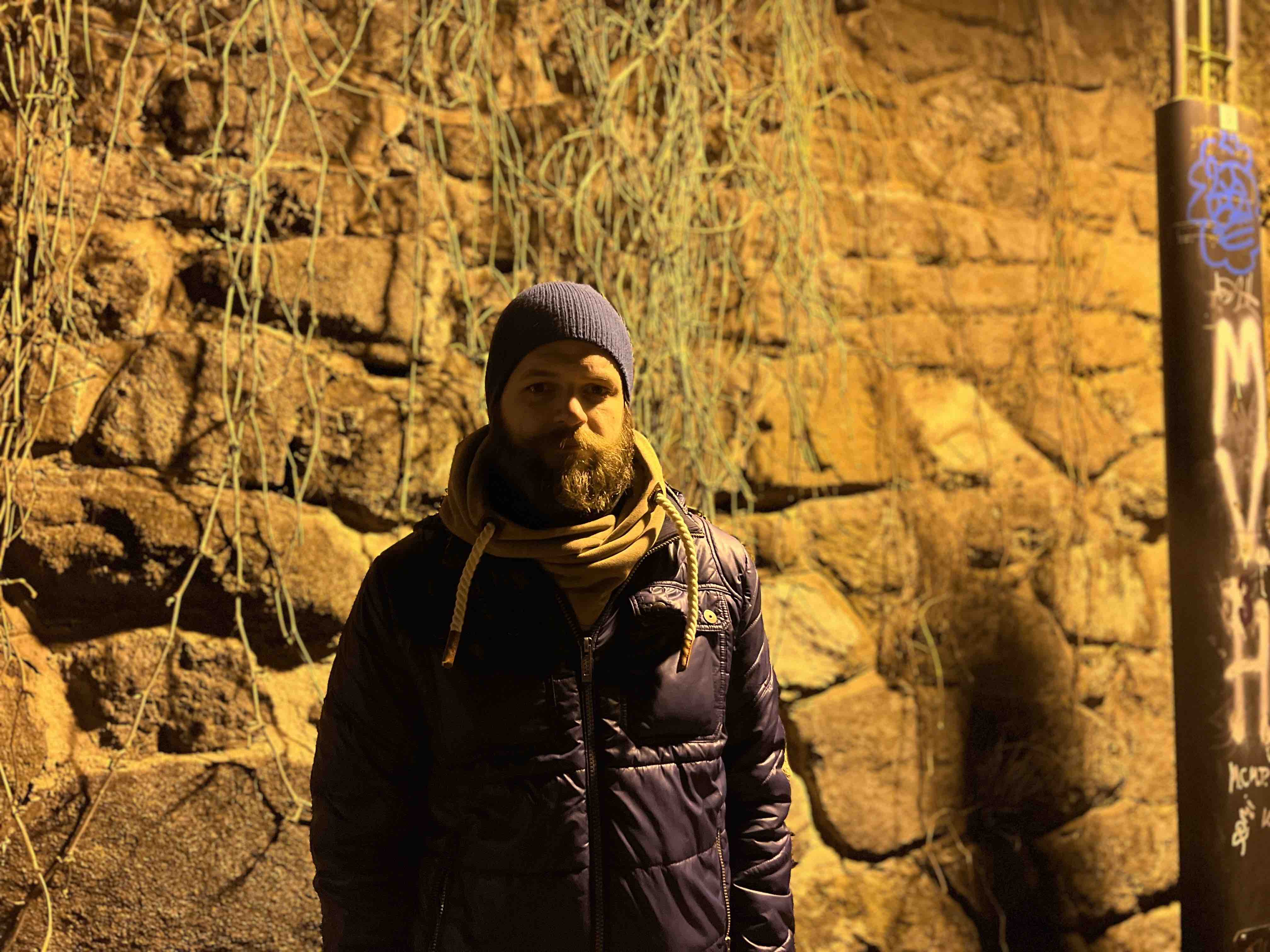 person standing against stone wall