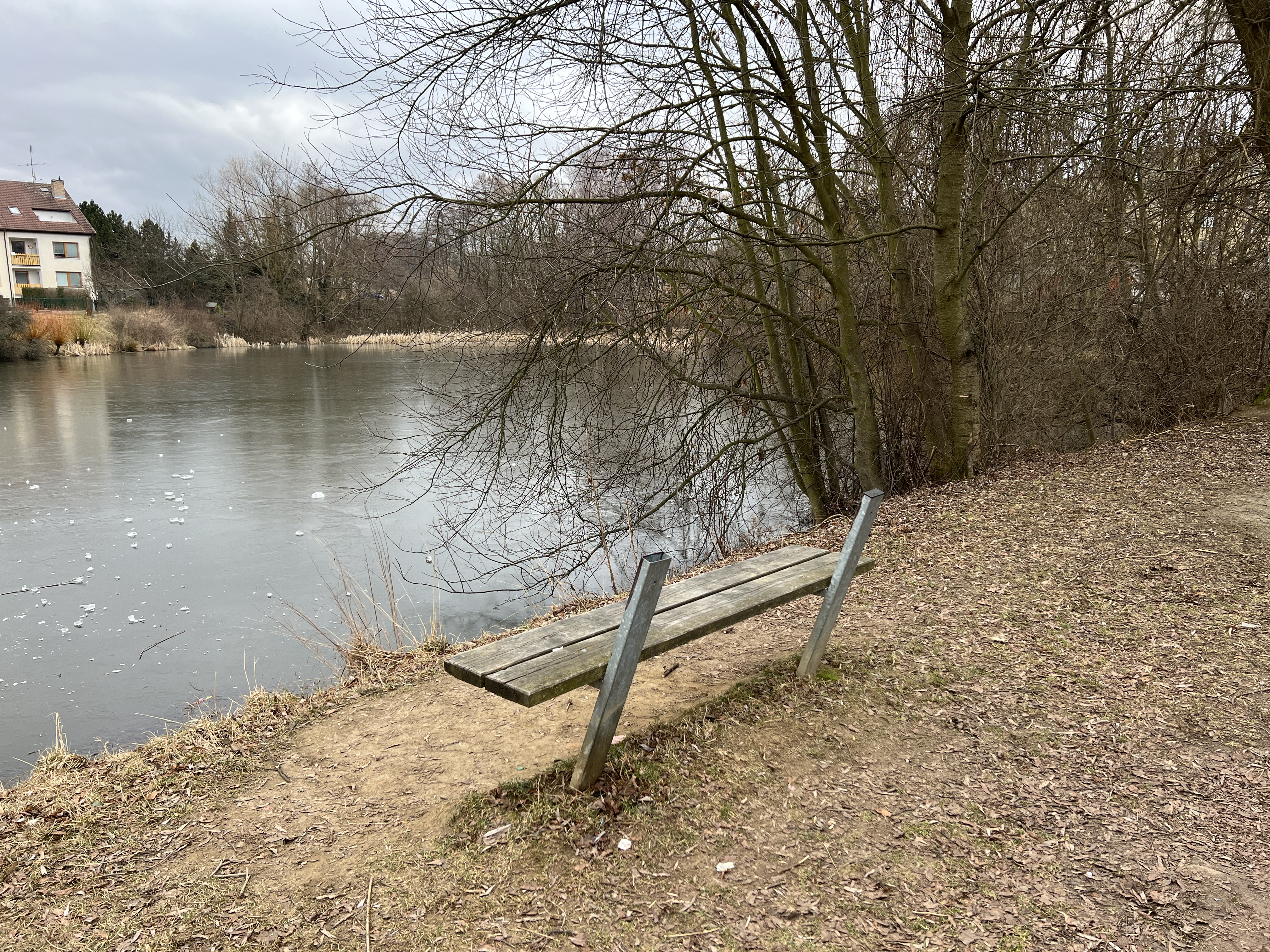 tilted bench by frozen lake