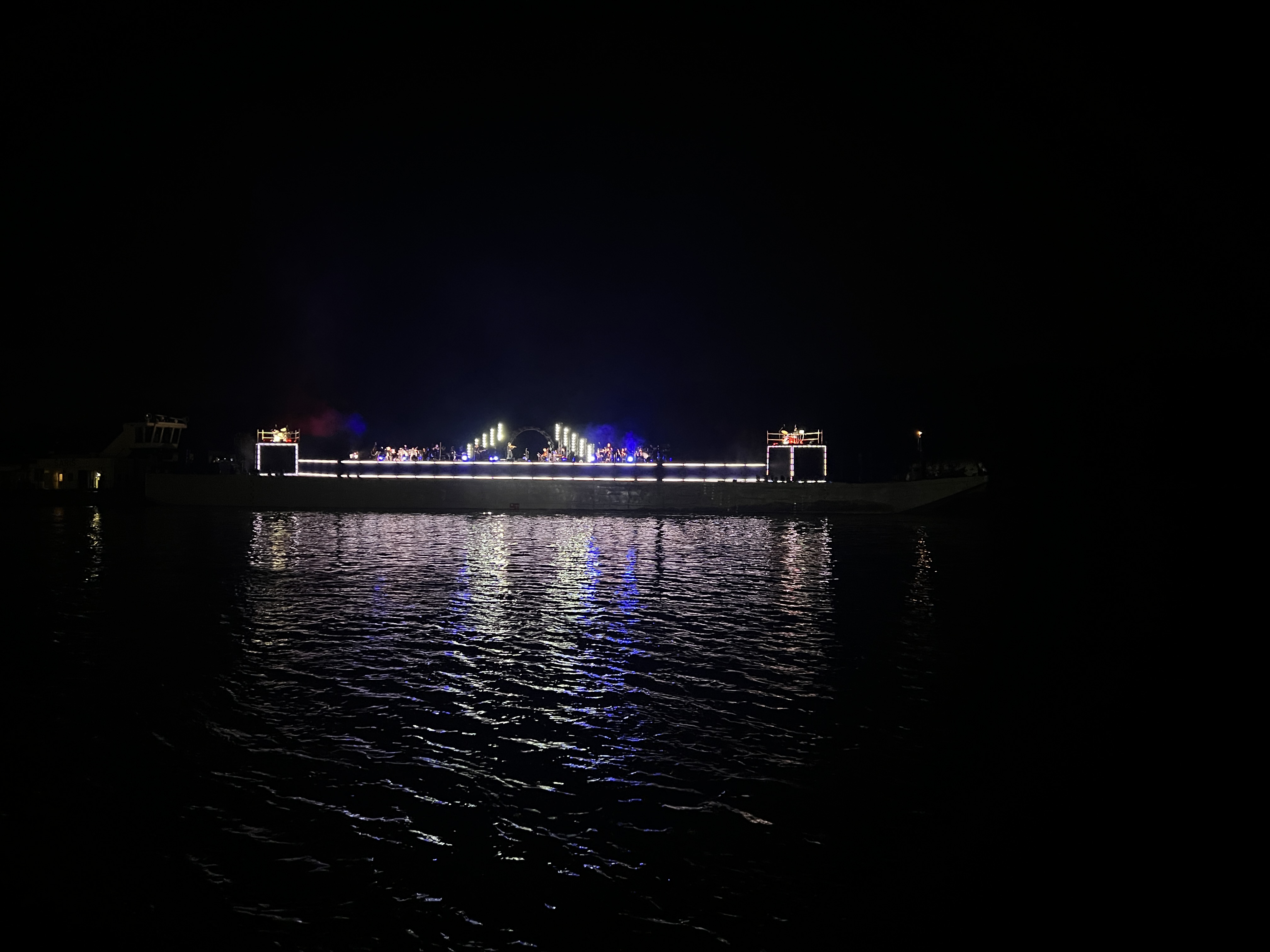 lit stage on water at night