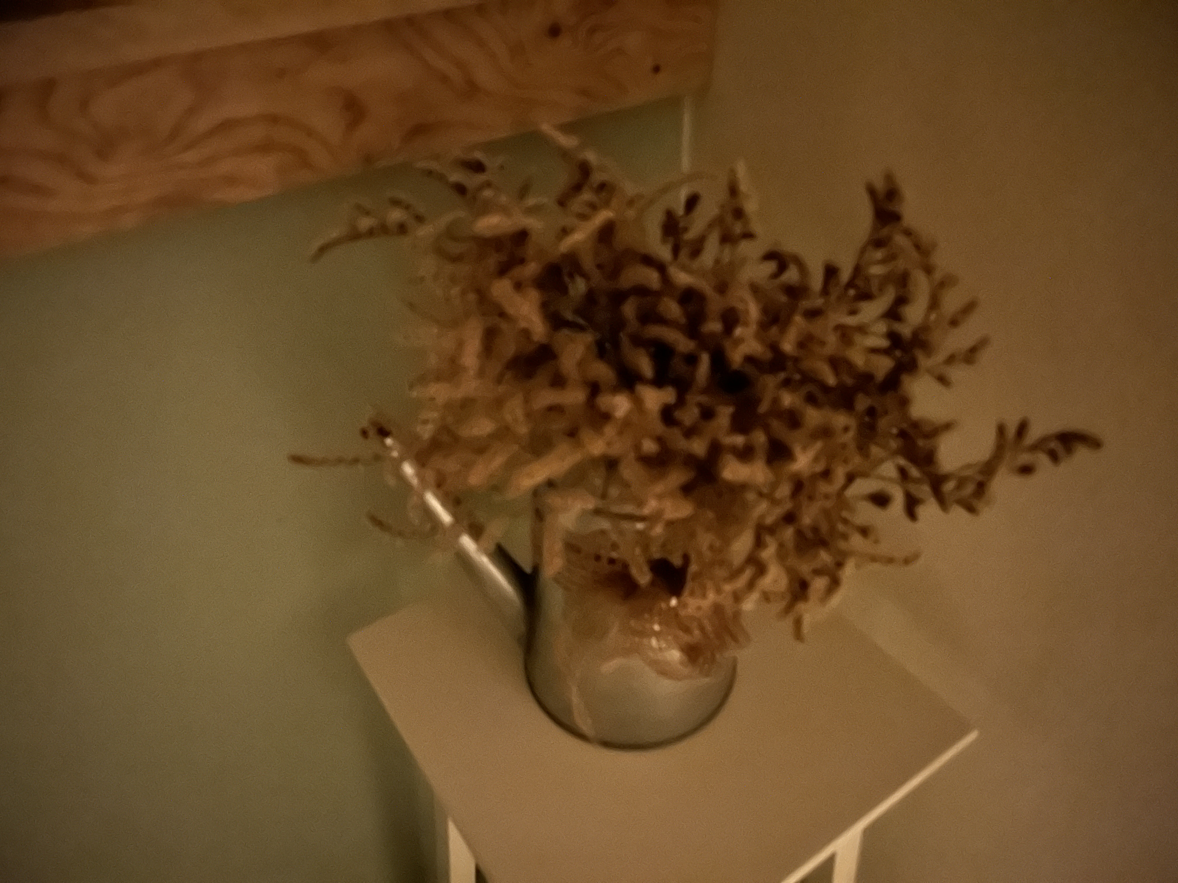 dried flowers in metal jug dim light